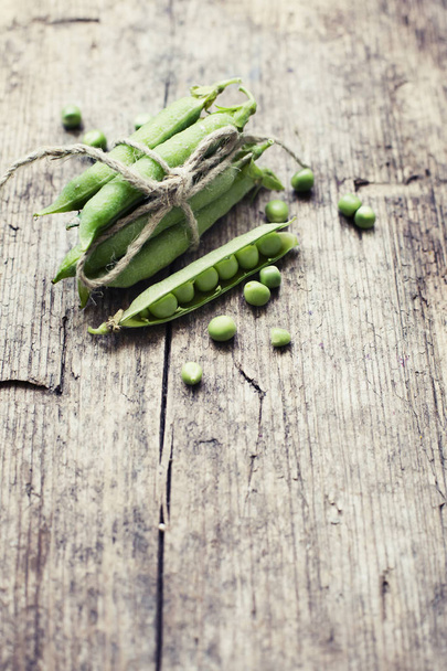 Top view of green peas on wooden background - 写真・画像