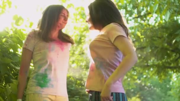 Beautiful girls stained with colored dust jumping and dancing, holi celebrating - Záběry, video