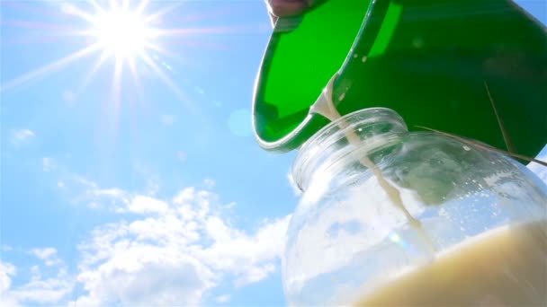 Fresh milk is poured into a glass jar. Slow-motion. Close-up - Footage, Video