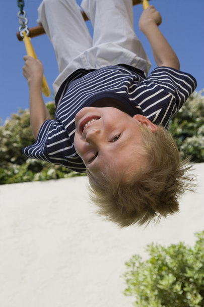 Little Boy Upside Down On A Swing - 写真・画像