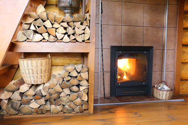 田舎の木造住宅で薪と薪ストーブします。薪、木材を燃焼とストーブのスタックで農村の家で部屋のインテリアの一部. - 写真・画像