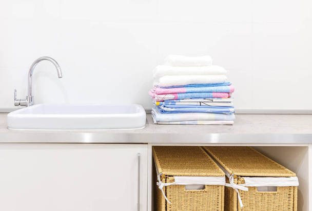 Moderno lavadero blanco con dos cestas
 - Foto, imagen
