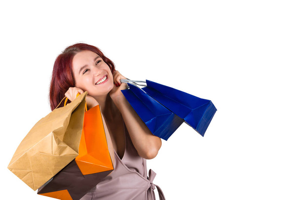 Beautiful jouyful young woman hands to cheeks holding shopping bags isolated over white background. - Photo, Image