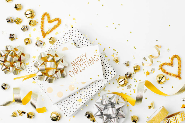 Christmas decorations and gift in gold colors on white background with scissors - Foto, Imagem