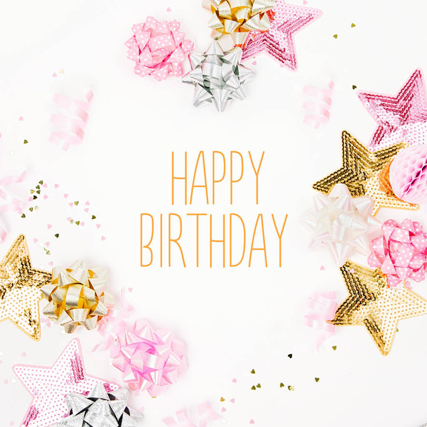pink and golden confetti, bows, paper decorations and happy birthday lettering on white background - Fotografie, Obrázek