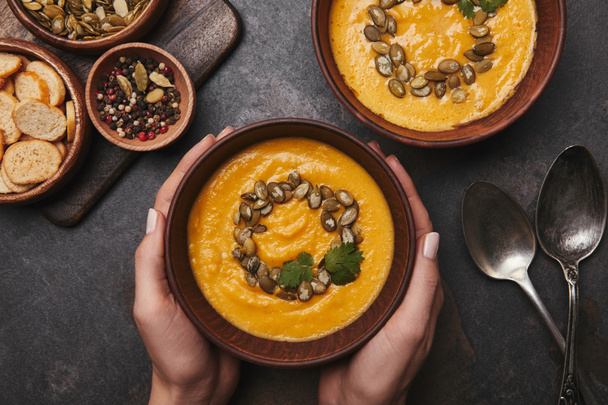 cropped shot of person holding bowl with delicious pumpkin soup - Photo, Image