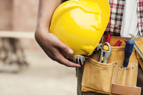 Close-up of hard hat holding by construction worker - Photo, Image