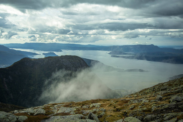 Un hermoso paisaje otoñal de montañas en el Parque Nacional Folgefonna con fiordo lejos en la distancia. Paisaje otoñal del sur de Noruega, colores otoñales en día nublado
. - Foto, imagen