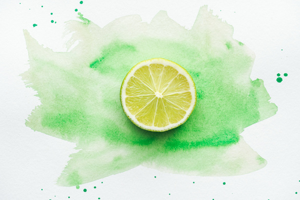 top view of piece of ripe citrus on white surface with green watercolor - Foto, Imagem