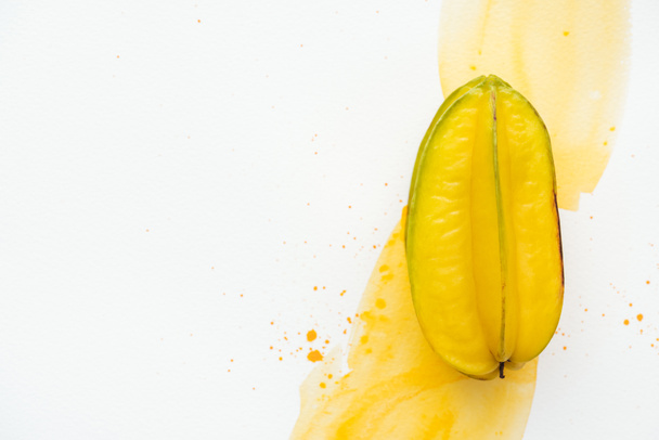 top view of one ripe carambola on white surface with yellow watercolor - Photo, Image