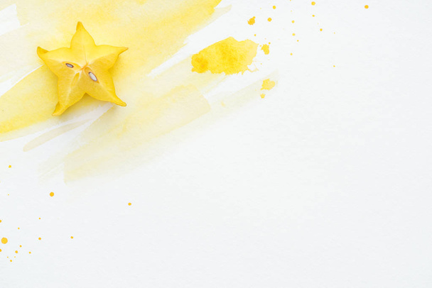 повышенный вид сладкой карамболы на белой поверхности с желтой акварелью
 - Фото, изображение