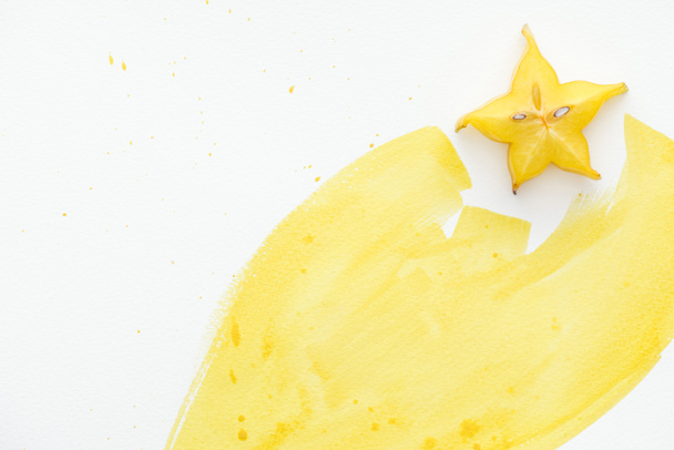 top view of carambola with yellow watercolor on white surface - Foto, Imagem