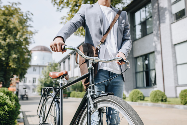 cropped view of stylish man walking with bicycle in city - Photo, Image