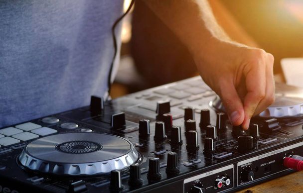 DJ воспроизводит и микширует музыку на цифровом контроллере midi. - Фото, изображение