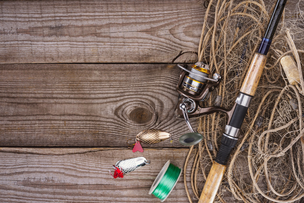 felülnézet, orsó, horgászbot, csali és halászháló, fából készült háttér  - Fotó, kép