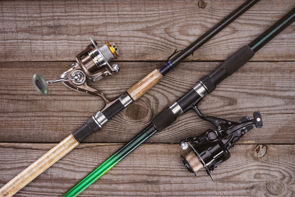 top view of fishing rods on wooden background, minimalistic concept  - Photo, Image