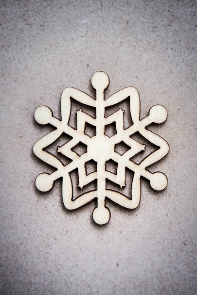Drewniane dekoracyjne śniegu na tle papieru rzemiosła, jako Boże Narodzenie dekoracje. Przyciemnione zdjęcie - Zdjęcie, obraz