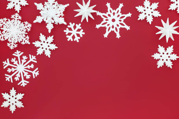 Decoraciones de bolas de copo de nieve blanco que forman un borde de fondo de Navidad en rojo. Tarjeta de felicitación tradicional de Navidad para la temporada festiva
. - Foto, Imagen