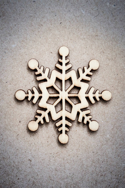 Wooden Decorative Snowflake on Craft Paper Background, as the Christmas Decor. Tinted photo - Photo, Image