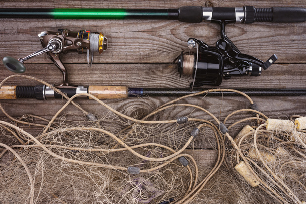 top view of fishing rods and fishing net on wooden planks  - Photo, Image