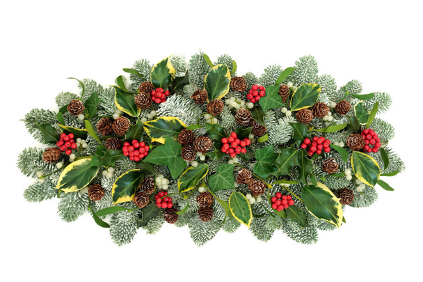 ヒイラギの果実、雪に覆われたスプルース パイン、アイビー、松ぼっくり、ヤドリギは、白い背景で隔離のクリスマスと冬の自然なテーブル デコレーション. - 写真・画像