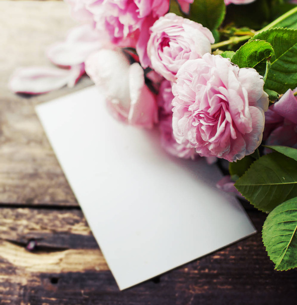 Amazing pink flowers with white paper for copy space on wooden background - Photo, image