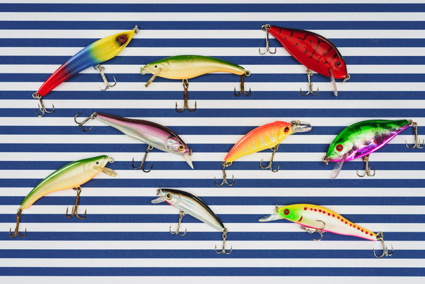elevated view of various fishing bait on striped background  - Foto, imagen