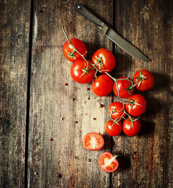Appetizing branch of tomatoes on wooden table - Foto, imagen