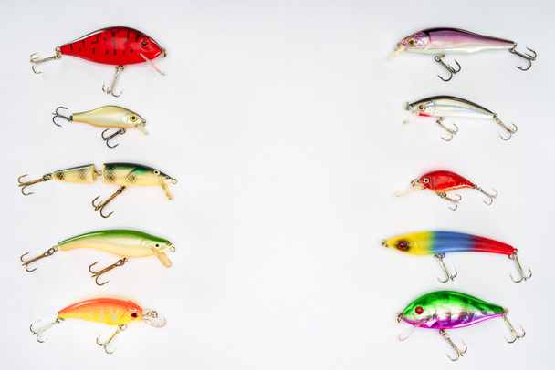 підвищений вид на різні рибальські приманки, поміщені в два ряди ізольовані на білому тлі
 - Фото, зображення