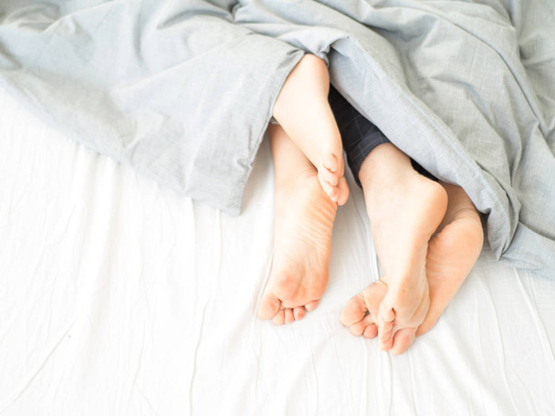 Close up view of a feet of a couple. Morning. Sensual awakening - Photo, Image