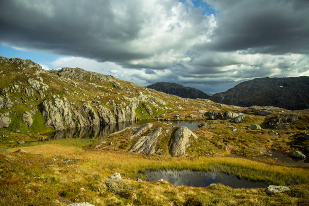 Piękny krajobraz góry jesień z niewielkim jeziorem. Naturalnej scenerii w norweskich górach. Małe wody staw w górach. - Zdjęcie, obraz
