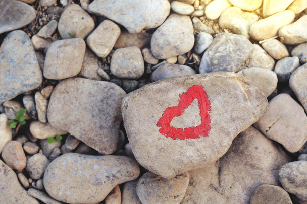 Pembe kalp birçok küçük taş zemin üzerine taş parçası üzerinde ruj ile boyalı - Fotoğraf, Görsel
