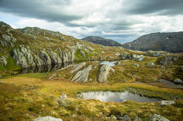 Piękny krajobraz góry jesień z niewielkim jeziorem. Naturalnej scenerii w norweskich górach. Małe wody staw w górach. - Zdjęcie, obraz