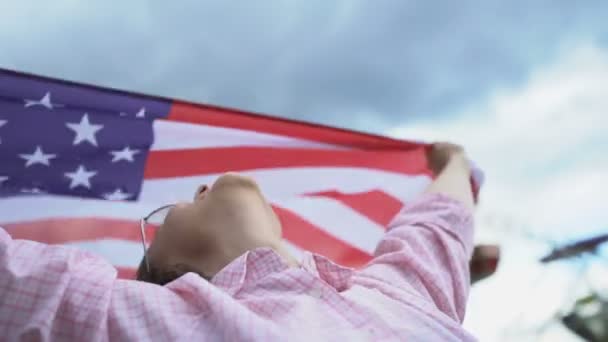 Woman waving US flag, patriot, secure future for young people in their country - Filmati, video