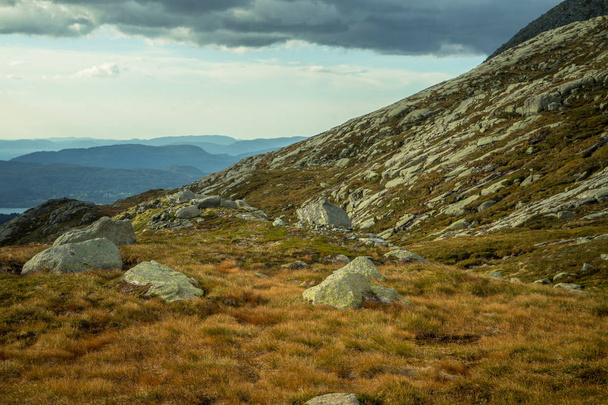 Un hermoso paisaje otoñal en el Parque Nacional Folgefonna en Noruega durante una caminata en tiempo ventoso y lluvioso. Montañas en Escandinavia. Paisajes otoñales en el desierto
. - Foto, Imagen