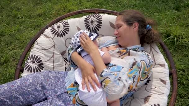 Mujer caucásica con bebé recién nacido en el jardín
. - Imágenes, Vídeo