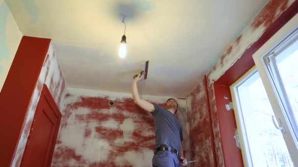 remont domu - pracownik szpachlowanie sufitu pokoju - Materiał filmowy, wideo