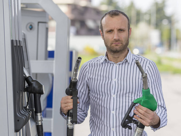 Unhappy man standing at the gas station - Fotoğraf, Görsel