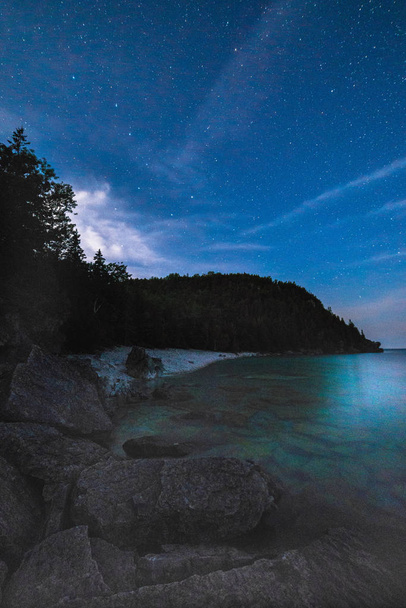 Vía Láctea y cielo estrellado con nubes a lo largo de la orilla del lago o
 - Foto, imagen