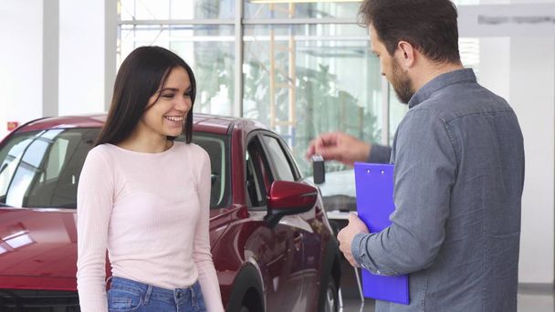 Arabanın anahtarlarını aldıktan sonra araba satıcısı ile tokalaşırken muhteşem mutlu kadın - Fotoğraf, Görsel