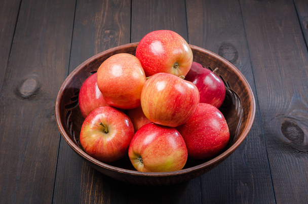 Red apples on a dark rustic background in a clay bowl.  Flat lay. - Fotografie, Obrázek