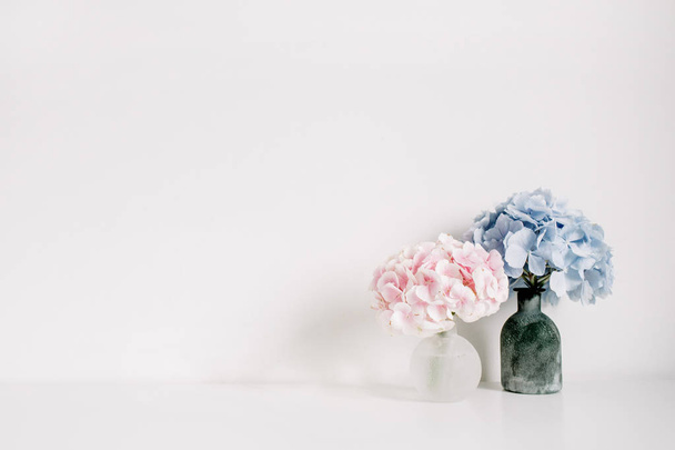 Ροζ και μπλε παστέλ Ορτανσία μπουκέτα λουλουδιών σε άσπρο φόντο. Ελάχιστη εσωτερική σχεδίαση. - Φωτογραφία, εικόνα