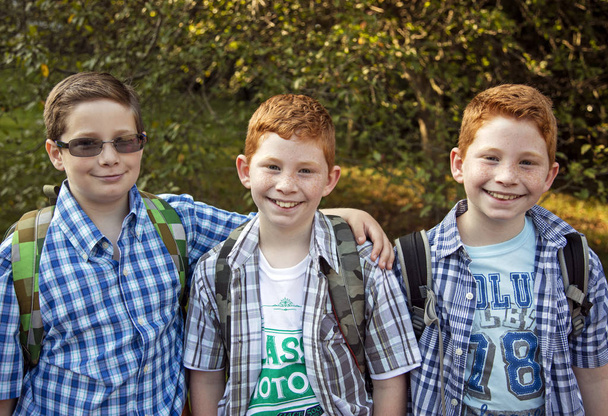 Троє хлопців чекають на шкільний автобус
 - Фото, зображення