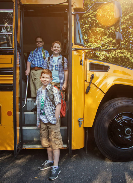 Gruppo di ragazzi salire sul loro scuolabus
 - Foto, immagini
