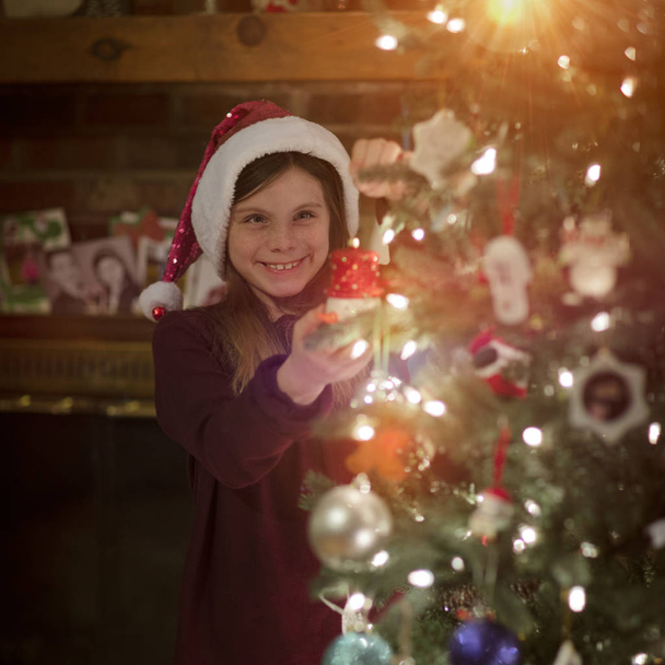 Kaunis tyttö roikkuu koristeet joulukuusi
 - Valokuva, kuva