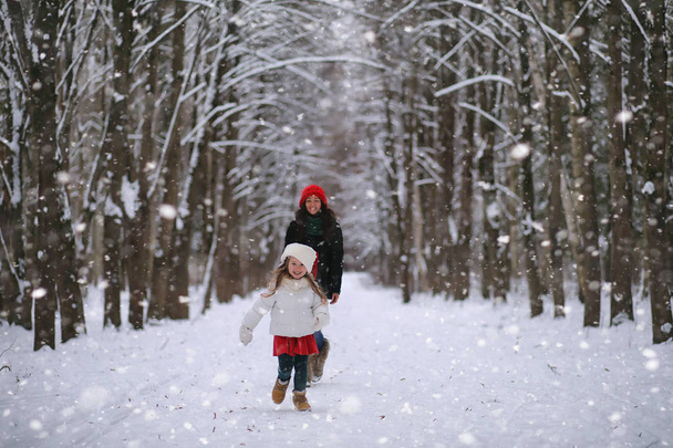 冬のおとぎ話、若い母と娘に乗るそり - 写真・画像