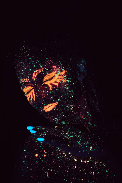 Portret dziewczynki namalowany w proszku fluorescencyjnym. Koncepcja Halloween. - Zdjęcie, obraz