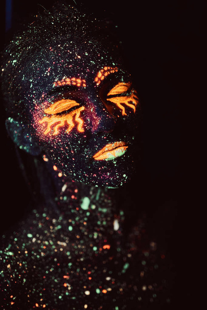 Portrait of a girl painted in fluorescent powder. Halloween concept. - Photo, Image