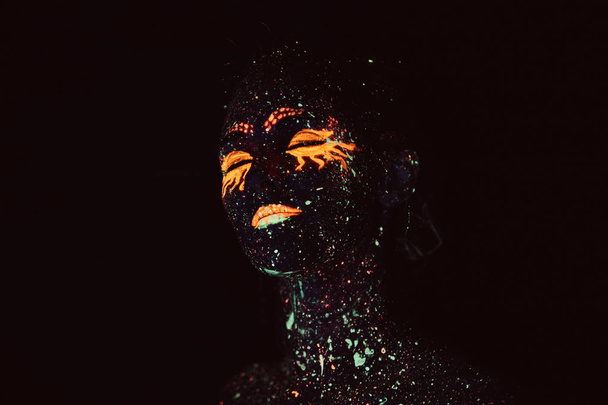 Portrait of a girl painted in fluorescent powder. Halloween concept. - Photo, Image