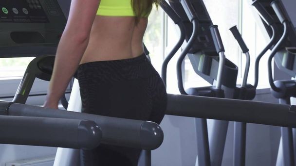 Close up shot of a sexy sportswoman with perfect butt running on a treadmill - Photo, Image